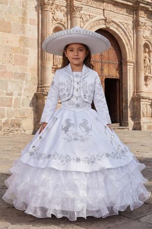 A girl wearing a traditional charro dress with silver embroidery with a sombrero in front of a colonial church