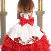 Bijan kids charro dress in white with red flowers embellished with rhinestones back with a big red bow and corset closure