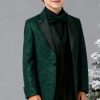 a boy's emerald green glitter suit with a pike lapel, matching vest and green pants Combined with a black shirt and a matching bowtie.