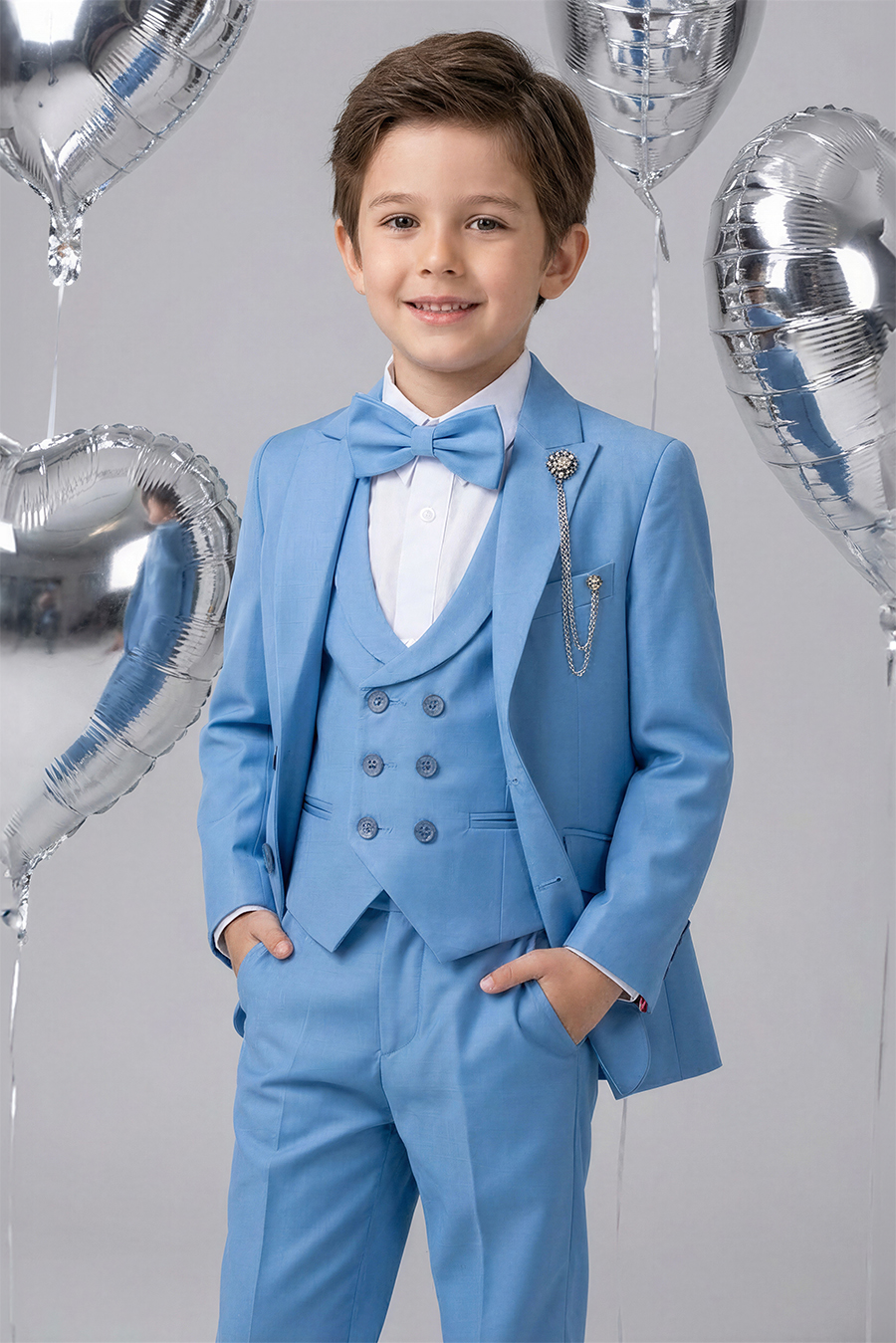 a boy wearing a light blue suit with a jacket, lapeled vest, white shirt, matching bow-tie, pants,