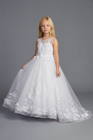 Young girl wearing a white sleeveless formal dress with floral appliqué bodice and full tulle skirt on a neutral background.