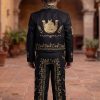 Boy wearing a black and gold charro mariachi suit with gold embroidered horseshoes and horse heads, gold metal buttons, matching sombrero, vest, white shirt, and bow tie.